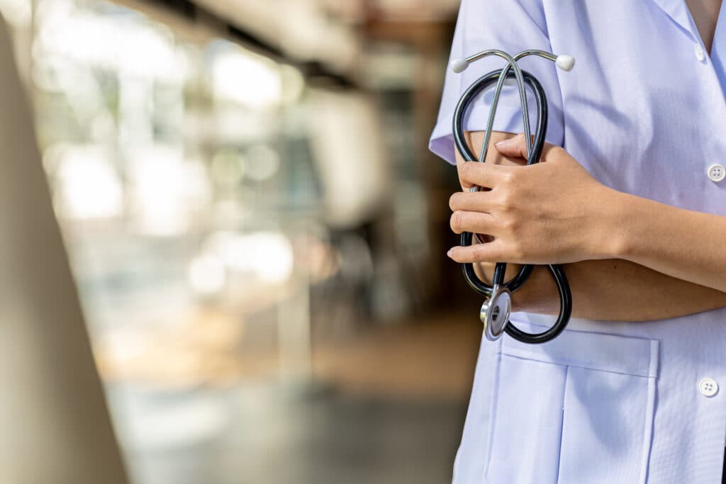 a-photograph-of-a-doctor-standing-with-his-arms-crossed-holding